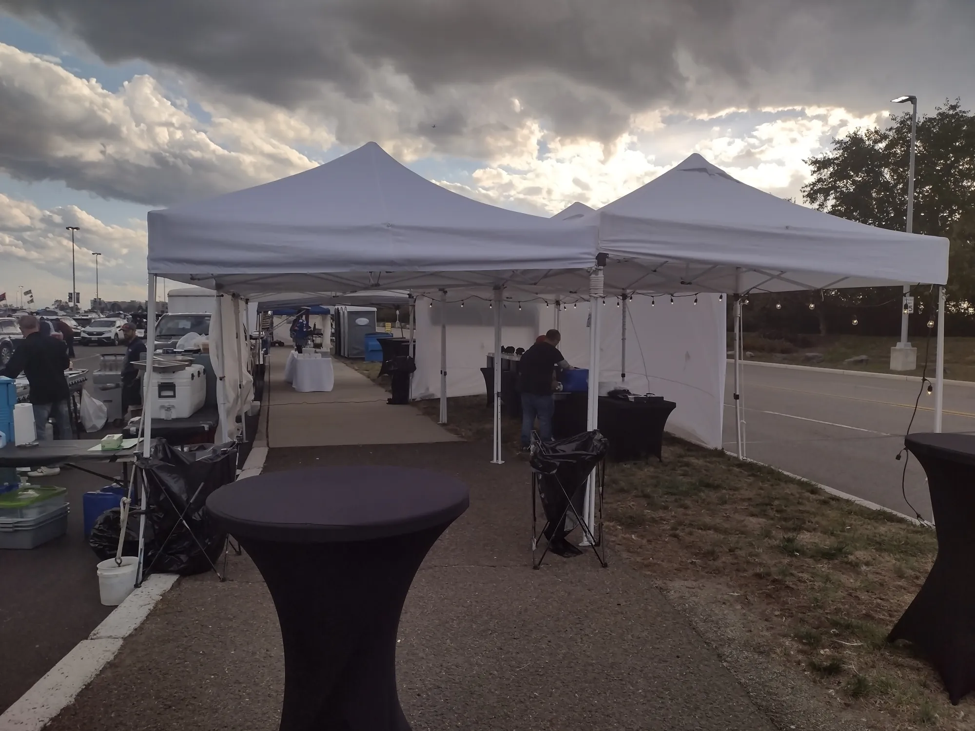 Tents and high-top tables set up at dusk
